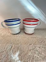 Front view of both striped Starbucks mugs