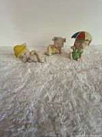 Three ceramic pig figurines on textured surface