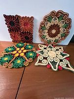 Group shot showing all four braided straw trivets assorted shapes and colours