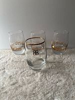 Front view of four tumblers showing gold rim and dot pattern