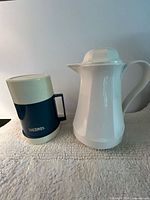 Navy/cream insulated pitcher and white carafe side by side