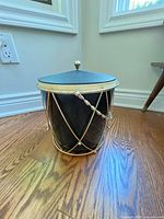 Full view of ice bucket with lid on showing gold-tone frame and black body
