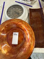 Group view of amber glass bowl, wall clock and ceramic tray