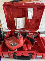 Open Milwaukee case showing drill, charger, battery, manual