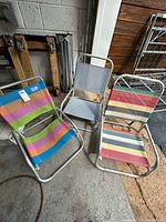 All three folding chairs standing on concrete floor