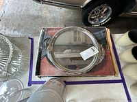 Round silver-plated tray resting on original box with surrounding items