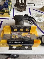 Skil palm sander, Stanley yellow miter box with saw in tray