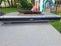 Front view of RCA DRC212N DVD/CD player with remotes on top