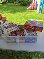 Tub containing several boxed games with Cranium and Twister visible on top
