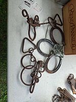 Two welded rod puzzles and horseshoe puzzle laid on table