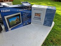 Both retail boxes: Haier 7" Digital Photo Frame and Element 7" Portable DVD Player