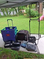 Group showing suitcase, rolling crate, folding metal cart, and amenity kits