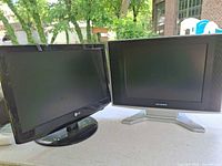Front view showing both televisions: LG on left, Sylvania on right