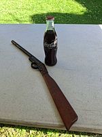 Toy rifle and Coca-Cola bottle on table