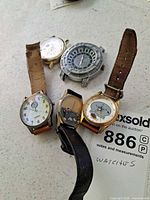 Group shot of all five watches showing cases and straps