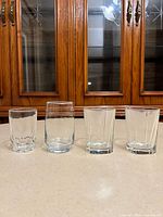Front view of all four clear glasses displayed in a row