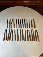 Full set of 34 wooden steak knives laid out in two rows