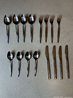 Full set laid out showing 4 knives, 4 forks, 4 large spoons, 4 small spoons