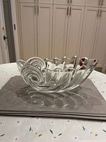 Side view of clear glass nautilus shell bowl showing ribbed swirl and scalloped rim