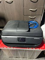Closed printer top with cable resting on lid