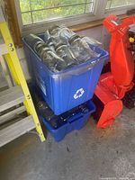 Blue recycling bins filled with many clear mason jars