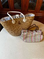 Straw tote and multicolour handbag on tabletop