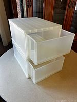 Two stacked translucent plastic drawer bins with drawers partially open