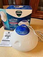 Vicks WarmSteam vaporizer, box, manual on countertop