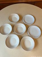 Group of five bowls and two plates showing matching design
