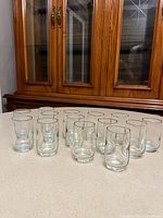 fourteen clear glasses arranged on countertop