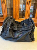 Front view of black Globetrotter duffle bag showing embroidered logo and overall shape