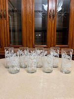 all eight tumblers grouped on counter in front of cabinet