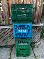 Front view of four stacked milk crates showing colors and embossing