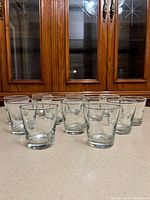 Twelve clear glass tumblers front view