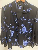 Front view of black chiffon blouse with blue floral print
