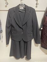 Full view of blazer and skirt on hanger