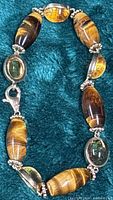 Full view of bracelet showing stones, gold links, and lobster clasp