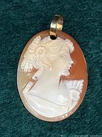 Front view of carved shell cameo pendant with bail