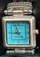 Close-up of ECCLISSI watch face showing turquoise dial and sterling case