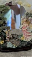 Front view of resin angel mirror showing figurines and arch
