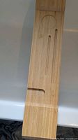Full view of bamboo bathtub tray across tub showing slots