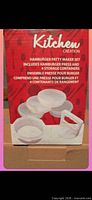 Front of retail box showing image and contents of hamburger patty maker set