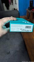 Side of teal box with barcode and regulatory info