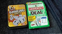 Monopoly Deal box and Bowling Dice tin together