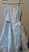 Front view of light blue spaghetti-strap bodice with floral appliqué and layered organza skirt