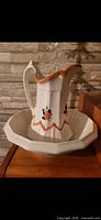 Pitcher resting in matching basin showing design details