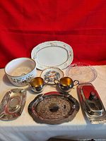 Group shot showing bone china platters, silver-plated trays, butter dish, glass plate, casserole bowl, and gold-lined sugar and creamer