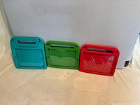 Front view of three foam iPad covers in teal, green and red