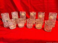 Front view showing all eleven lace-covered glass candleholders in two height groups