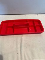 Top view of red plastic compartment tray showing handle and compartments